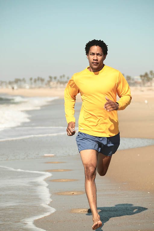 A Person Running on a Beach With the Ocean in the Background