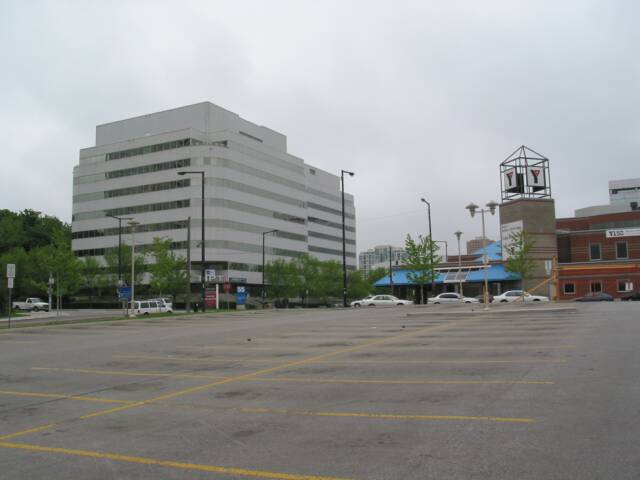 Photo of a Parking Lot With a Large White Building in the Background