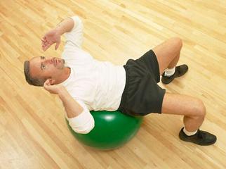 A Person Exercising on a Green Exercise Ball in a Gym