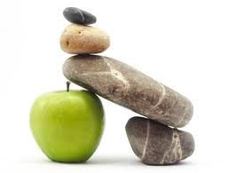 A Stack of Rocks Balanced on Top of a Green Apple